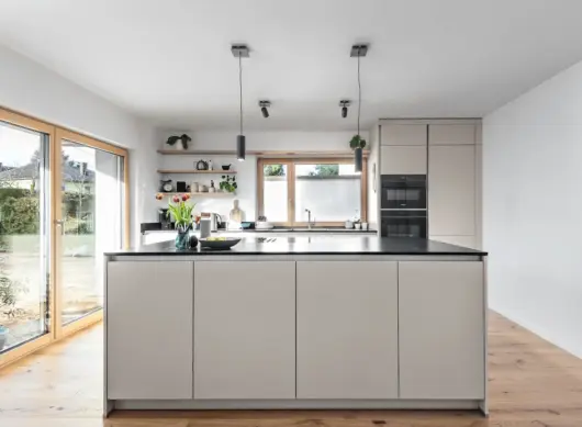 Moderne Danküche im Modell Silbermond in der Frontfarbe Jasmin und dunkler Arbeitsplatte.