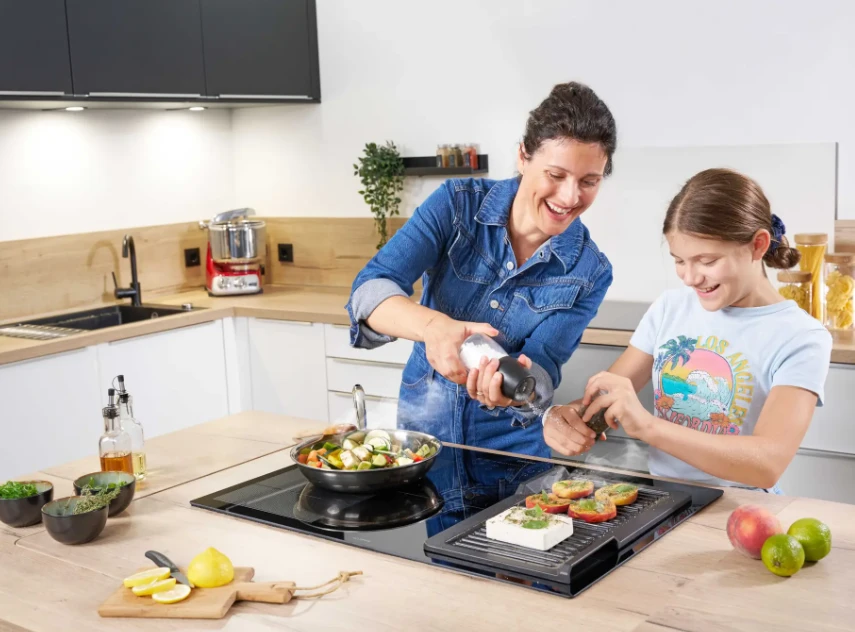 Mutter und Kind beim Kochen mit dem Induktionskochfeld von Oranier