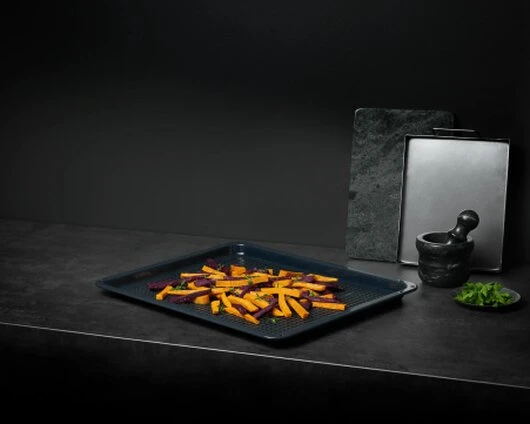 Airfry Backblech AEG Airfry Backblech auf dunkler Arbeitsplatte befüllt mit Gemüse.