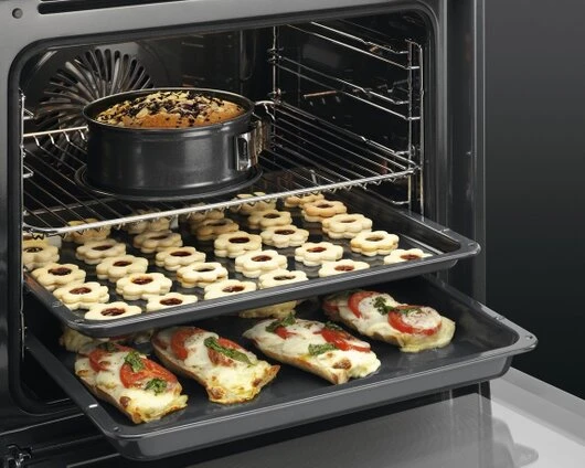 Dampfbackofen mit gefüllten Backblechen AEG Dampfbackofen mit zwei gefüllten Backblechen und oberbei einem vollen Topf.